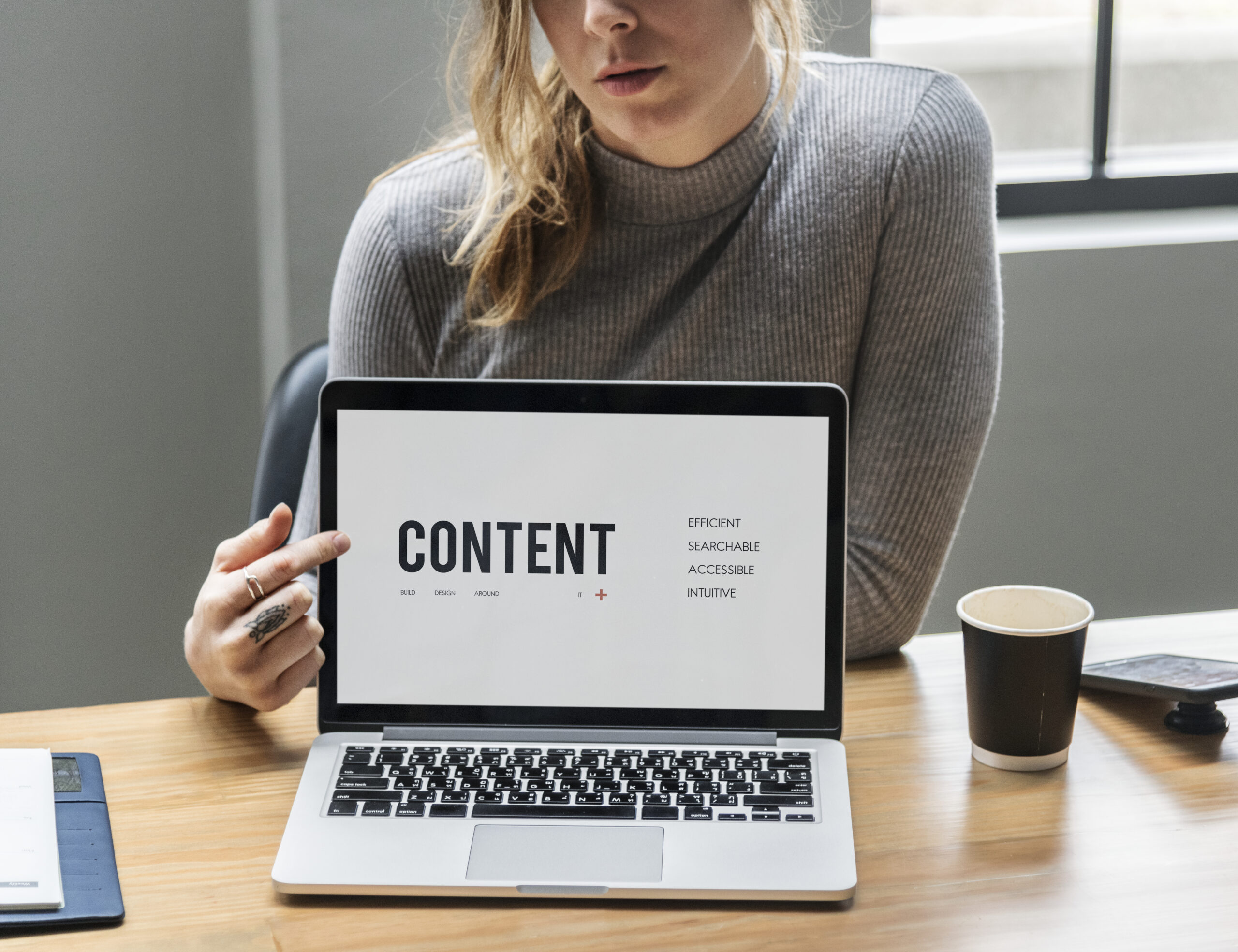 Blond Woman Pointing At A Laptop Screen